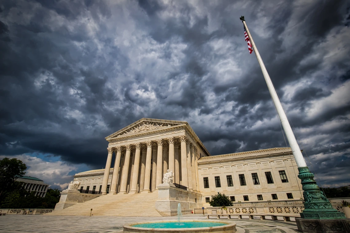 dark clouds loom over a wide-angle shot of the U.S. Supreme Court