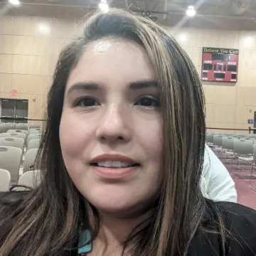 A portrait of Millicent Pepion taken as a selfie in an empty conference room.